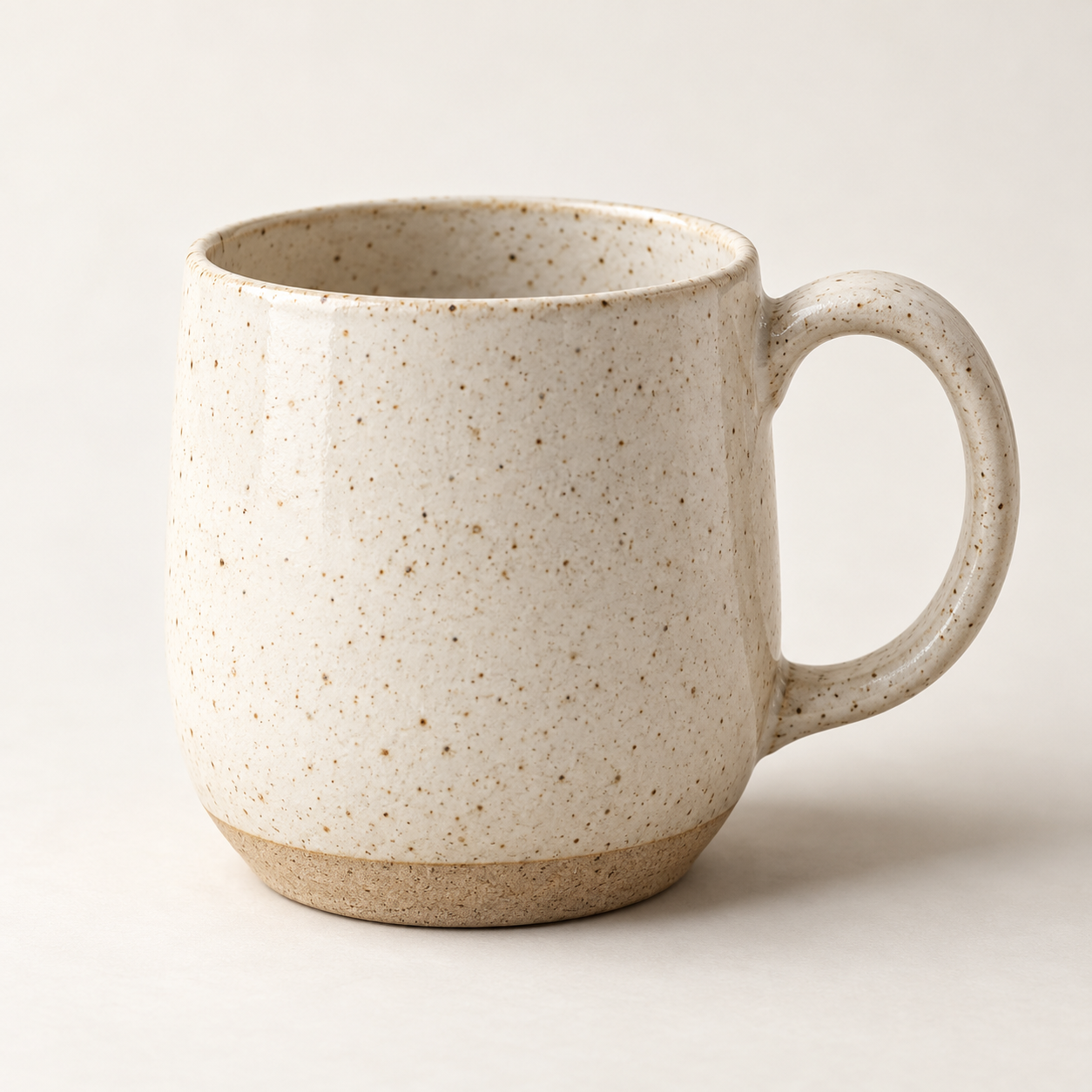 Speckled ivory stoneware mug with a natural ceramic base